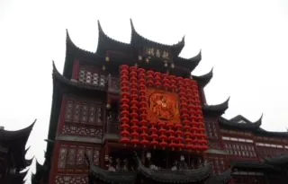 Traditional Chinese architecture with intricate roof design and red lanterns, showcasing cultural heritage and style.