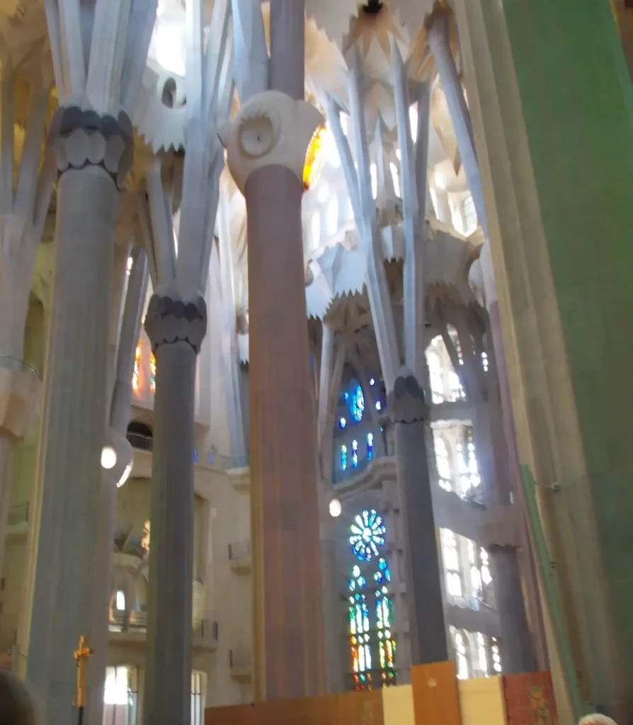 Interior of a cathedral with stained glass windows and tall, intricate columns.