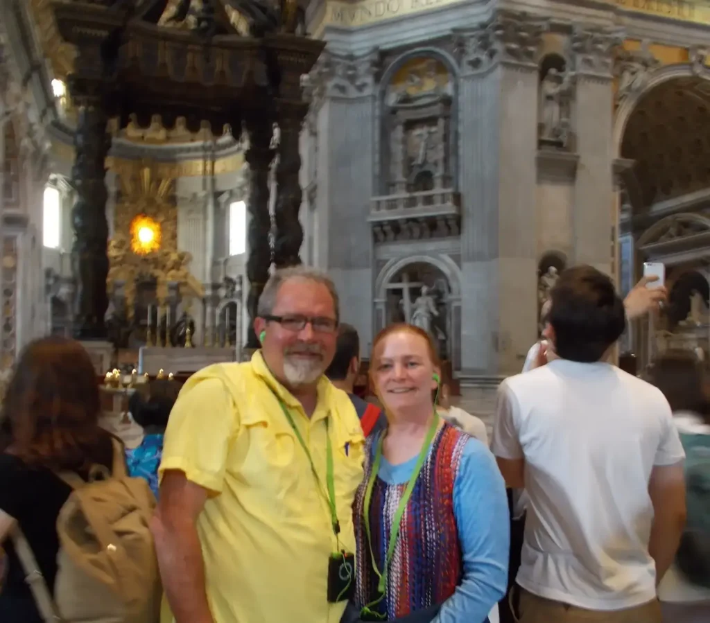 Tourists inside stunning architectural hall with intricate stonework and ornate columns.